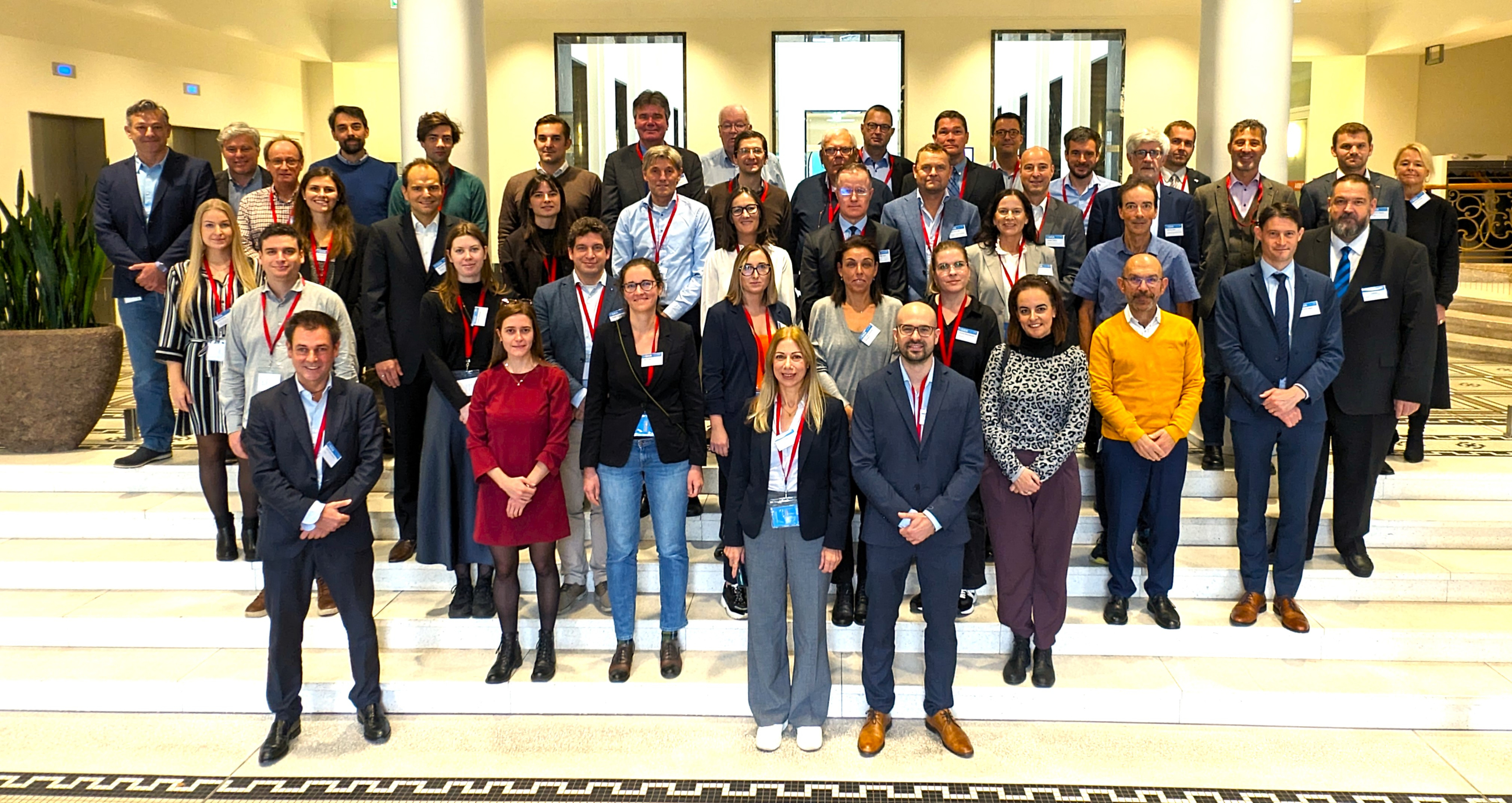 The attendees of the kick off meeting of the European Network on Impact of Climate Change on Aviation standing in the hallway in the headquarters of EASA