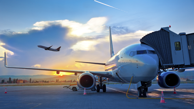 An aircraft on the ground connected to the apron for boarding