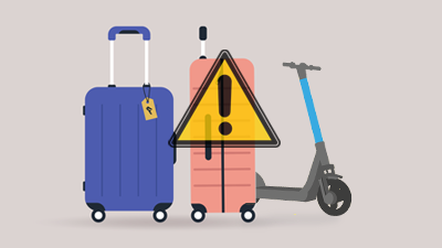 Two pieces of luggage, an e-scooter and a warning sign on top